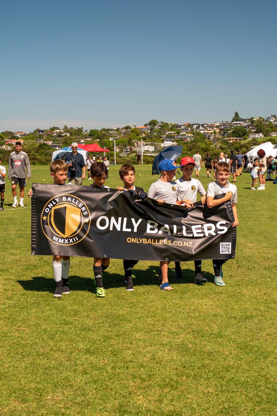 Young Only Ballers players proudly holding the club banner on match day